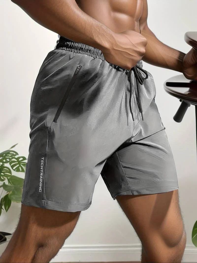 Moderne man draagt ademende activewear korte broeken voor mannen met verstelbaar trekkoord en veilige ritszakken, perfect voor sportieve activiteiten.