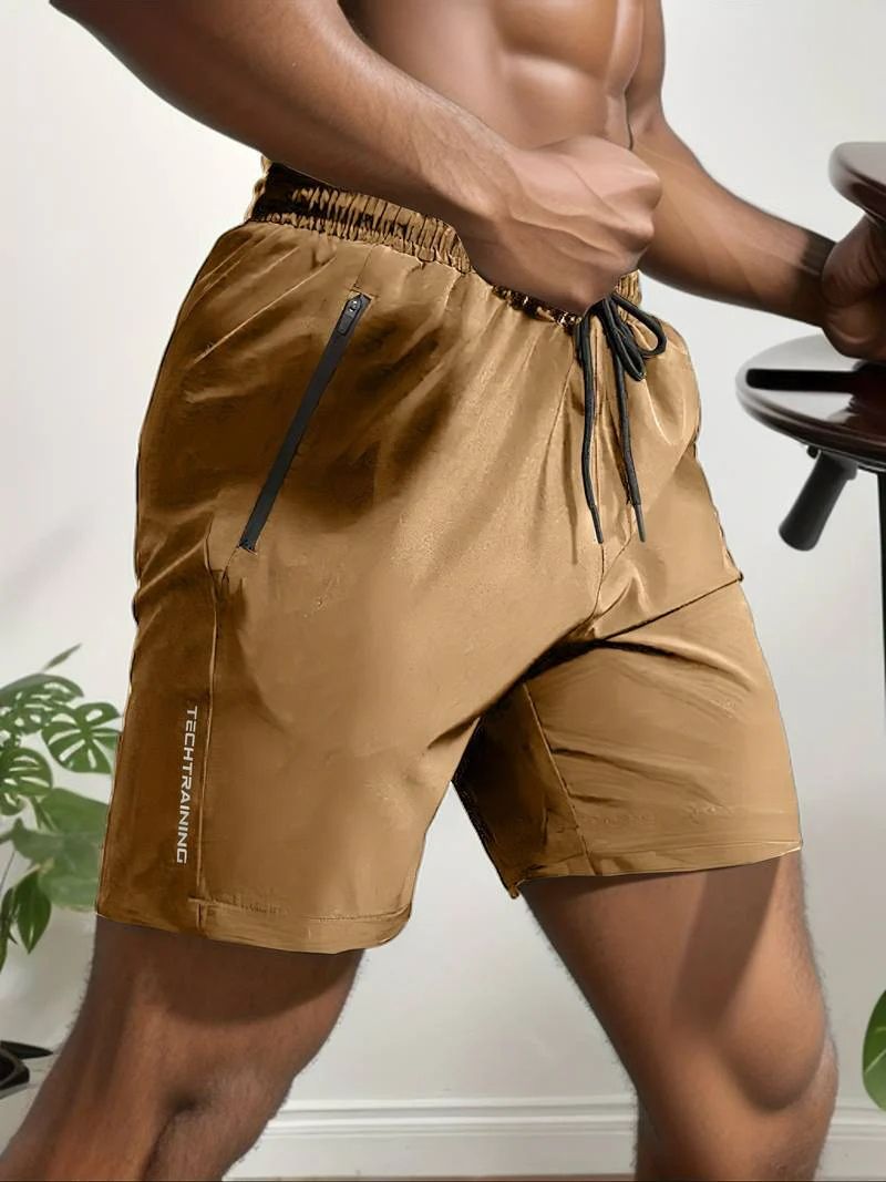 Moderne man draagt ademende activewear korte broeken voor mannen met verstelbaar trekkoord en veilige ritszakken, perfect voor sportieve activiteiten.