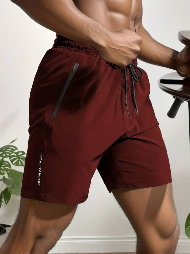 Moderne man draagt ademende activewear korte broeken voor mannen met verstelbaar trekkoord en veilige ritszakken, perfect voor sportieve activiteiten.